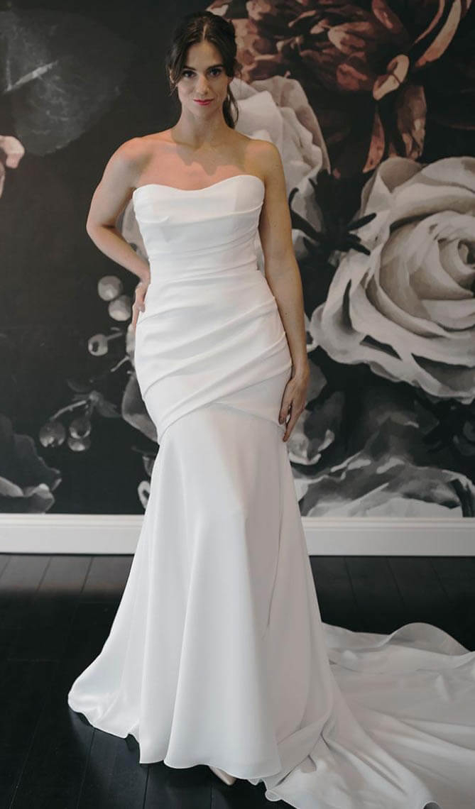 Model wearing a white gown by Paloma Blanca